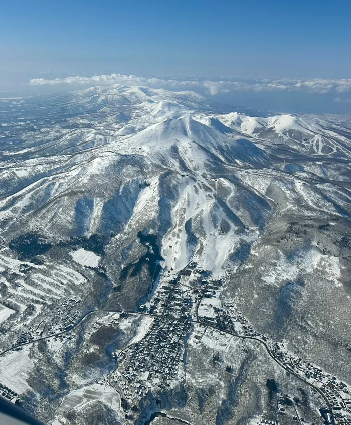Aerial view of Kutchan town under deep snow with Mt Annupuri and the Niseko range behind